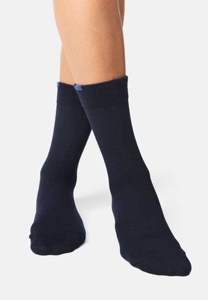 Calcetines de algodón azul marino con puño acanalado. Textura suave, de longitud hasta el tobillo con acentos contrastantes en azul más claro cerca de la parte superior.