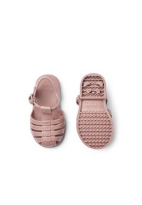 Różowe gumowe sandały z paskami, regulowaną sprzączką oraz teksturowaną podeszwą o falistym wzorze. Odpowiednie do codziennego użytku.