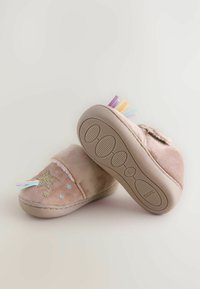 Chaussons en velours rose avec des embellissements en étoile et paillettes, avec des pompons colorés à l'avant et des semelles en caoutchouc texturé pour une meilleure adhérence.
