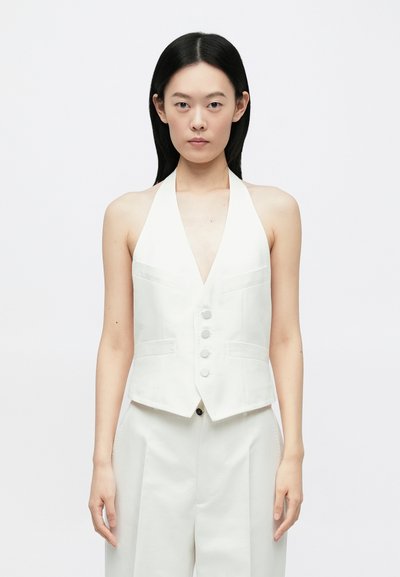 Witte haltertop met een diepe V-hals, voorzien van vijf knopen en gestructureerde zakken. Gladde stof, getailleerde pasvorm.