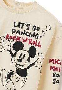 Tela color crema con ilustración de Mickey Mouse bailando y el texto "VAMOS A BAILAR ROCK'N'ROLL" junto a notas musicales.