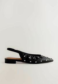 Svart slingback-sko i slät läder, med spetsig tå och dekorerad med silvernitar över ovandelen. Låg kvadratisk klack.