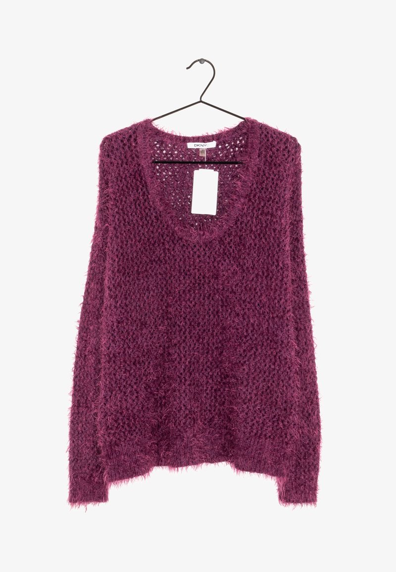 Stickad tröja i djup lila. Har en lös, strukturerad design med en bred halsringning och långa ärmar. Hänger från en svart klädhängare.