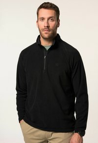 Schwarzer Fleece-Pullover mit Reißverschluss vorne, langen Ärmeln und leichter Textur. Verfügt über ein dezentes Logo auf der Brust und einen hohen Kragen.