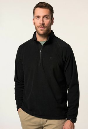 Pullover in pile nero con zip frontale, maniche lunghe e una texture leggera. Presenta un logo discreto sul petto e un colletto alto.