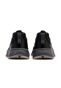 Zwarte sportieve schoenen met een getextureerde mesh bovenzijde, rubberen zool en een trekband. Voorzien van merknaam op de hiel en een contrasterende lichtgekleurde buitenzool.