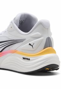 Λευκό αθλητικό παπούτσι με υφασμάτινη άνω επιφάνεια με υφή και μαύρες λεπτομέρειες. Διαθέτει επενδεδυμένο πέλμα, μεσαία σόλα με βαθμιαία μετάβαση από πορτοκαλί σε κίτρινο και λογότυπο "NITRO".