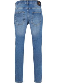 Jeans de mezclilla en azul claro, con un corte slim, diseño de cinco bolsillos y costuras en contraste. Cintura estándar con etiqueta en la parte posterior.