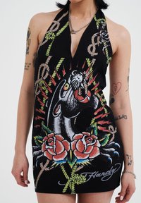 Black halter dress featuring a bold graphic design of a panther, roses, and rope motifs. Notable colorful details and a plunging neckline.