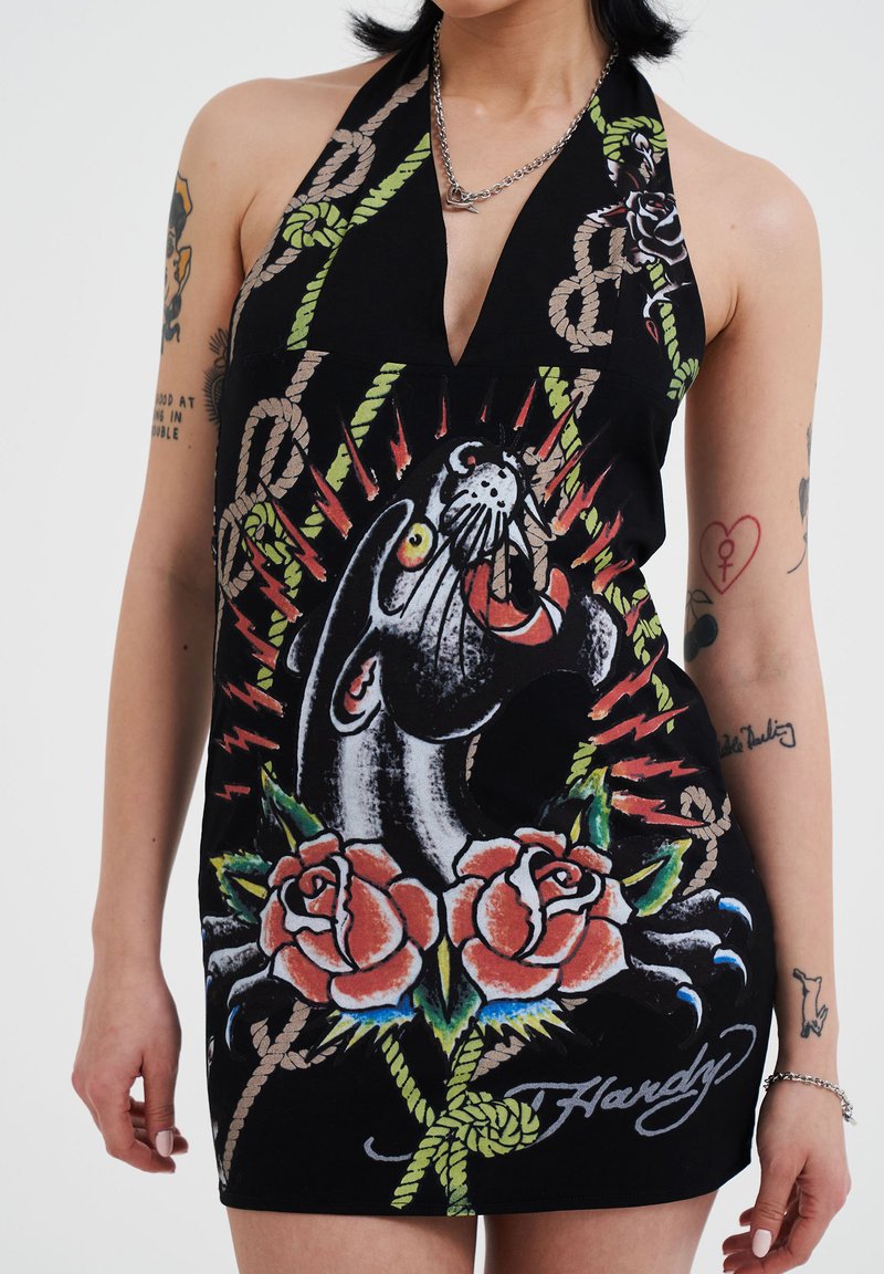 Black halter dress featuring a bold graphic design of a panther, roses, and rope motifs. Notable colorful details and a plunging neckline.