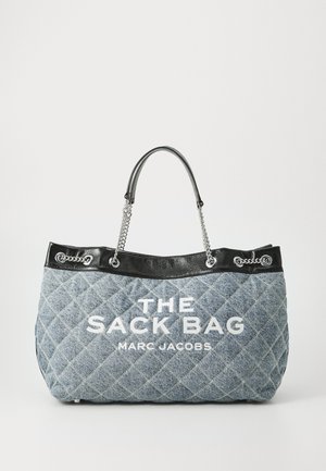 Quiltet denim tote bag med sorte læderdetaljer, dobbelthåndtag og sølvhardware. Har fed hvid tekst: "THE SACK BAG MLC JACOBS."