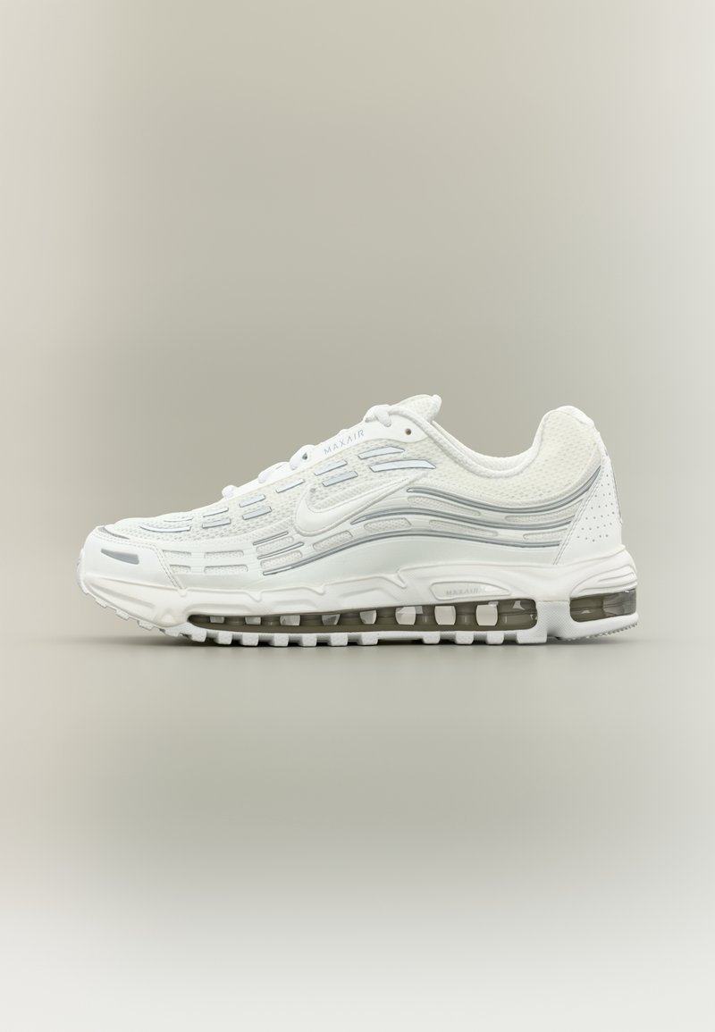 Baskets blanches Nike Air Max avec semelle à coussin d'air visible, dessus texturé et détails gris subtils sur fond neutre.