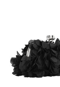 Bolso de mano negro con pétalos florales hechos de tela, cierre metálico plateado con dos acentos redondos, forma compacta y superficie texturizada.