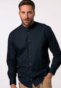 Camicia blu navy con colletto alla coreana, caratterizzata da bottoni dorati sul davanti e maniche lunghe, realizzata in un tessuto liscio.
