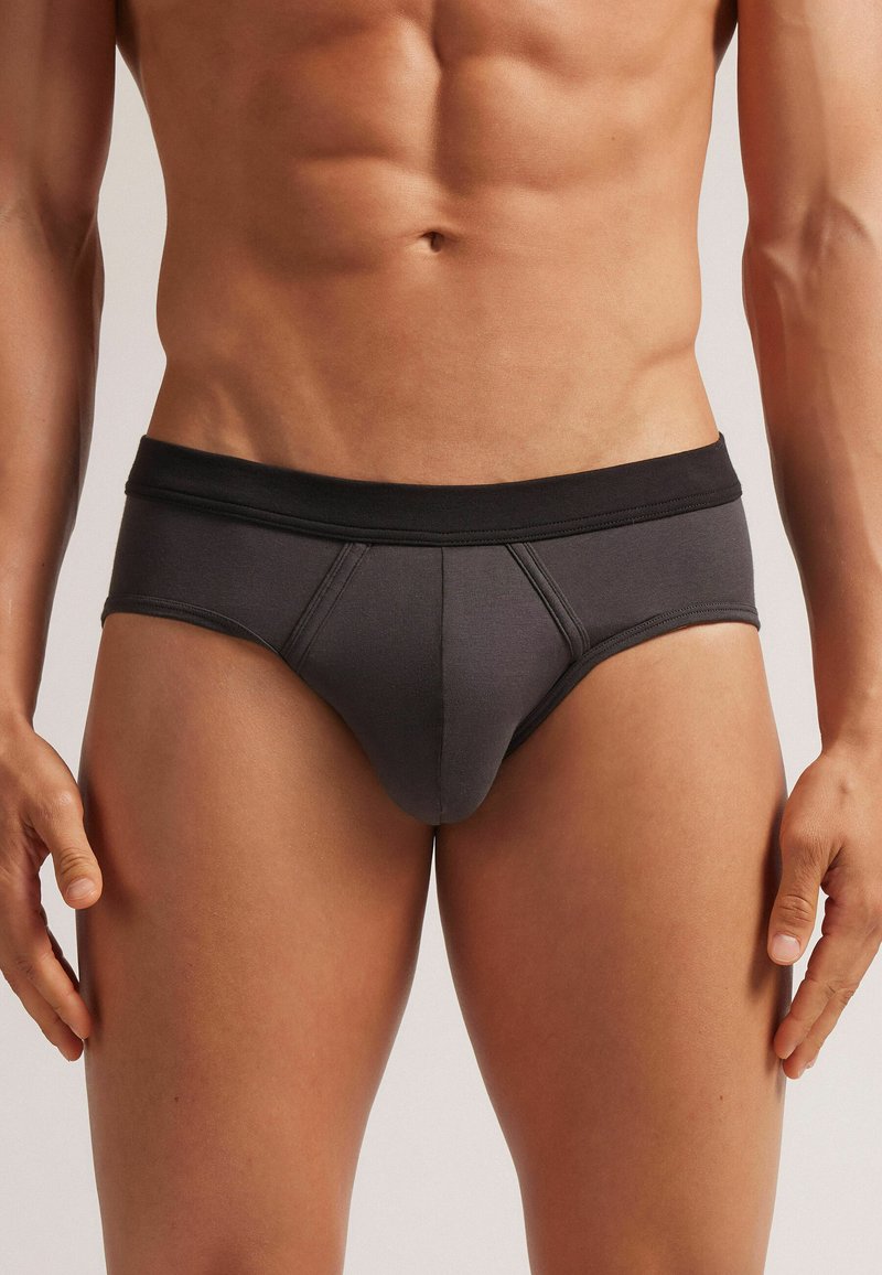 Dunkelgraue Unterhose aus weichem Stoff, mit einem schwarzen elastischen Bund und glatten Nähten. Der konturierte Vorderteil verbessert die Passform.