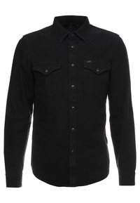 Mustapohjainen pitkähihainen paita, jossa on napillinen kaulus, rintataskut ja valkoiset ompeluyksityiskohdat. Ominaista on klassinen lännen tyyli.