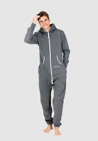 Grijze hoodie jumpsuit met een ritssluiting aan de voorkant, twee zijzakken en witte accenten. Gemaakt van zachte stof, met een losse pasvorm en taps toelopende benen.