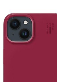Közelkép egy bordó telefontokról, amelyen dupla kamera kivágás és logó látható, kiemelve elegáns formatervezését és élénk színét.