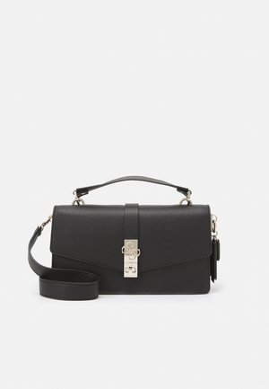 Sac à main en cuir noir avec poignée supérieure et bandoulière amovible, avec un fermoir argenté orné du logo sur le devant.