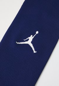 Marineblå sokk med ribbet tekstur, med en hvit brodert Jumpman-logo på midten av leggen. Lett og designet for sportsklær.