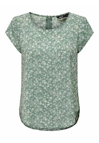 Blouse florale verte à manches courtes et col rond, avec une fermeture éclair dans le dos et un tissu texturé décoré de motifs de fleurs blanches.