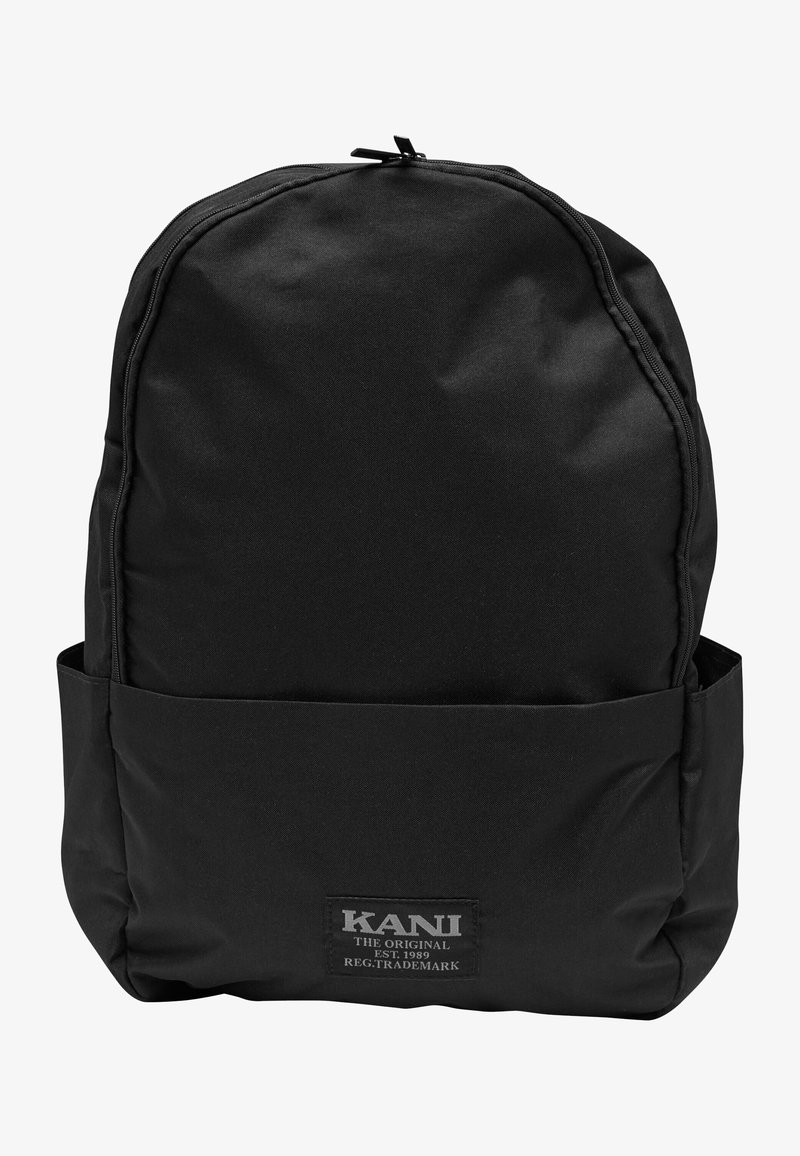 Svart tygryggsäck med rundad topp, framficka, KANI-logotyp och dragkedjestängning. Hållbart material med en slät yta.