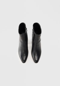 Sorte lær ankle boots med spiss tå, jevn tekstur og glidelåser på siden, med et minimalistisk design og medium høyde.