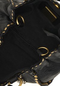 Interno di una borsa in pelle nera con dettagli in metallo dorato e cuciture visibili. Foderata in tessuto scuro, presenta una forma strutturata e un laccetto.