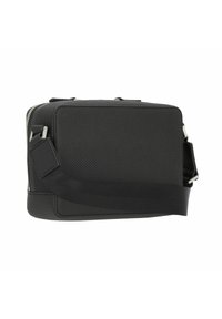 Black rectangular crossbody bag with a textured synthetic surface, zip closure, adjustable strap, and a small detachable tag.