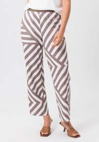 Pantalons larges à motifs en rayures zigzag marron et blanc, fabriqués en tissu léger, avec une taille confortable et des poches latérales.