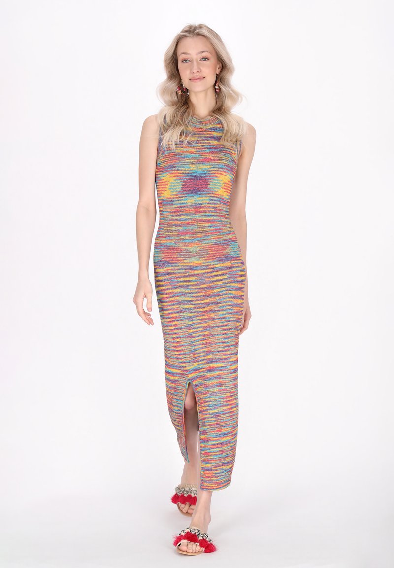 Abito maxi in maglia colorato con design senza maniche, caratterizzato da uno spacco laterale. Sandali morbidi rossi completano il look.