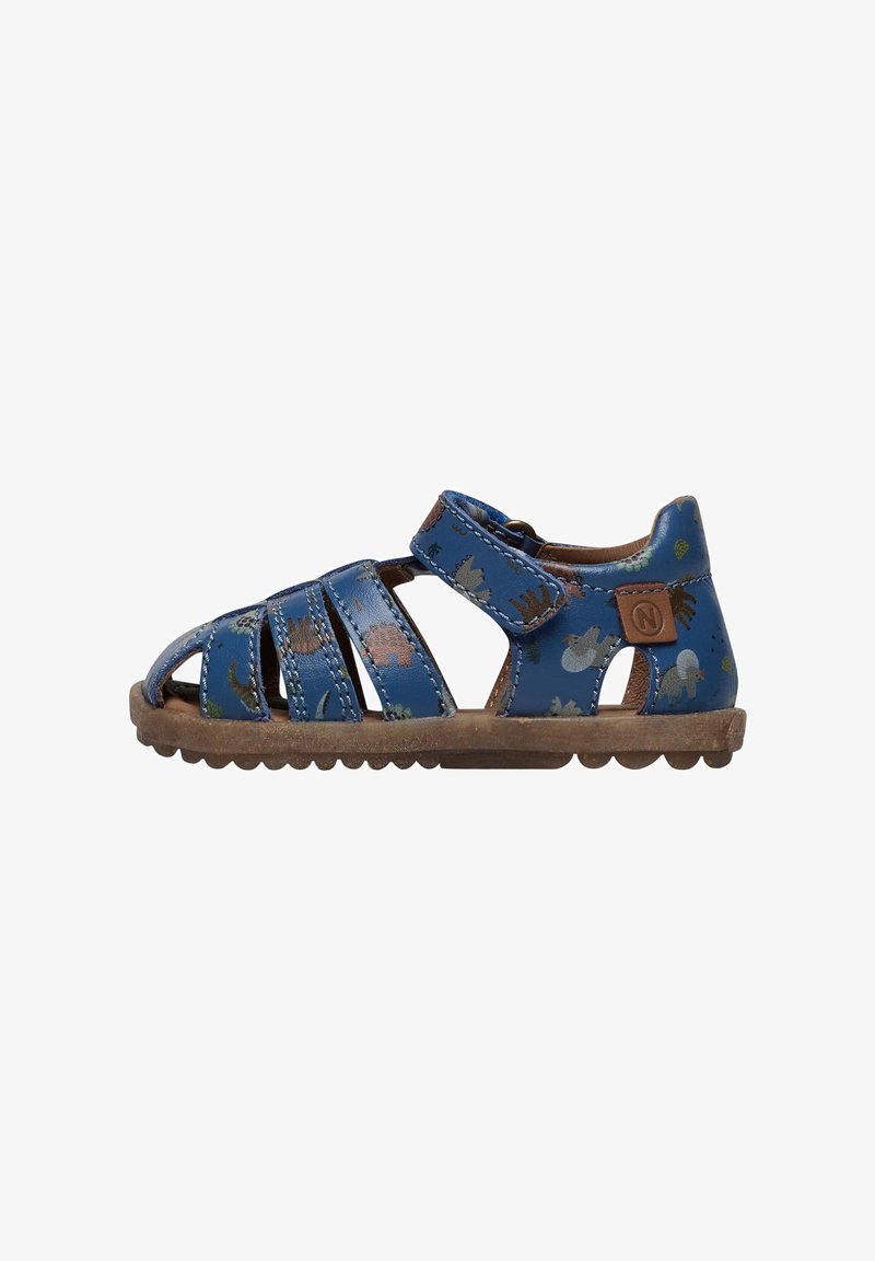 Des sandales en cuir bleu présentent un design découpé avec plusieurs lanières, ornées d'un motif de dinosaure coloré, et une semelle en caoutchouc avec une prise texturée.