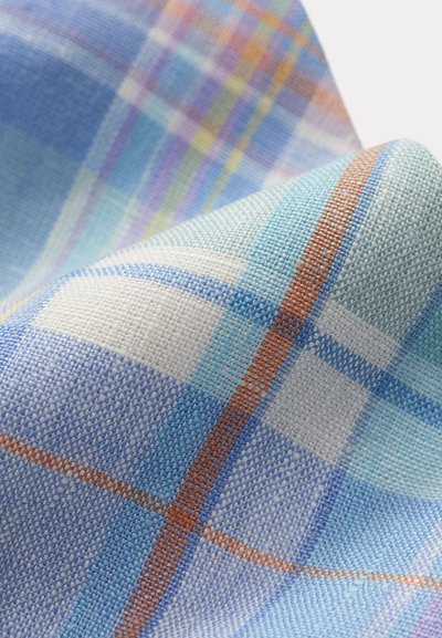 Κοντινό πλάνο διπλωμένου μπλε και λευκού καρο υφάσματος με πορτοκαλί και ανοιχτό μπλε διασταυρούμενες ρίγες και υφή ύφανσης.