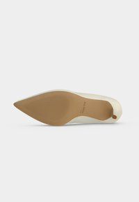 Chaussure plate beige pour femme à bout pointu vue de la semelle, avec une semelle texturée antidérapante et le nom de la marque ALDO imprimé sur la semelle.