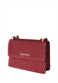 Borsa a tracolla rossa trapuntata con hardware dorato e chiusura a patta. Presenta un motivo in rilievo e il logo del marchio sul davanti. Design compatto e strutturato.
