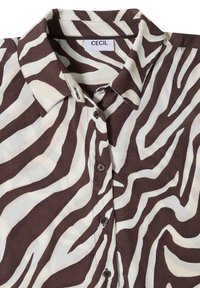 Chemise à col rayée zèbre marron et blanche avec boutons et une étiquette indiquant "CECIL" à l'intérieur du col.