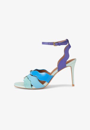 High-Heel-Sandale mit wellenförmigen, geschichteten Riemen in Mint, Hellblau, Blau und Lila, mit einem Knöchelriemen mit goldener Schnalle.