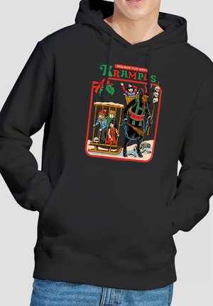 Krampus wearing chains and carrying a broom, dragging a cage with three children, a skull, and a skeleton on a black hoodie.