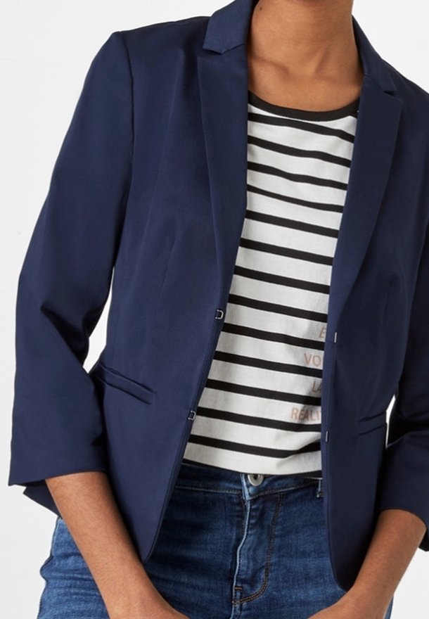 Navy blue blazer with a tailored fit, two buttons, and three-quarter sleeves, layered over a striped shirt and denim jeans.