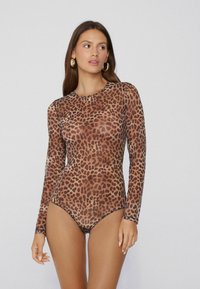 Dlouhé rukávy body vyrobené z průhledné látky se vzorem hnědých a černých leopardích skvrn, s kulatým výstřihem a přiléhavým siluetou.