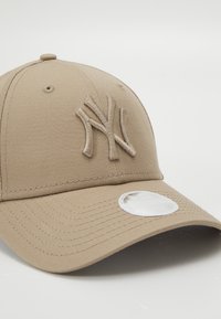 Casquette de baseball beige en coton, ornée d'un logo NY brodé. Texture douce avec des coutures renforcées et une visière plate.