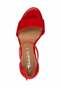 Red sandal featuring a suede upper, glossy patent toe strap, and a smooth, neutral insole. Adjustable ankle strap with buckle detail.