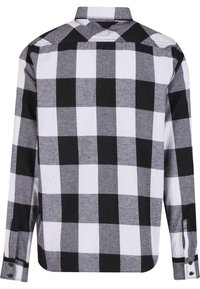 Geruite shirt met zwart-witte vierkanten, lange mouwen, knopenmanchetten en een geplooide kraag. Gemaakt van zachte, gestructureerde stof.