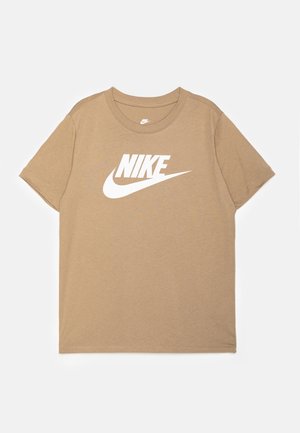 Beżowy T-shirt z krótkim rękawem z białym logo Nike i znakiem Swoosh na środku klatki piersiowej, z okrągłym dekoltem, położony na płasko na białym tle.