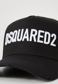 Gorra de béisbol negra de tela con el logo bordado en blanco "DSQUARED2" en la parte frontal, con un visor curvado tradicional.