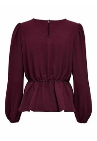 Bordeauxblus i texturerat tyg. Den har långa puffärmar, en nyckelhålrygg och en samlad midja med en peplumslut.