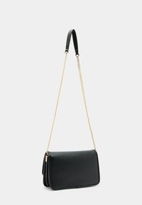 Sort læder crossbody taske med en struktureret overflade, guld kædetræk og flaplukning. Firkantet form uden synlige mønstre.