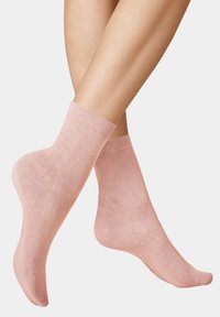 Light pink ankle socks made of soft, textured fabric, featuring a ribbed cuff and subtle pattern for added detail.