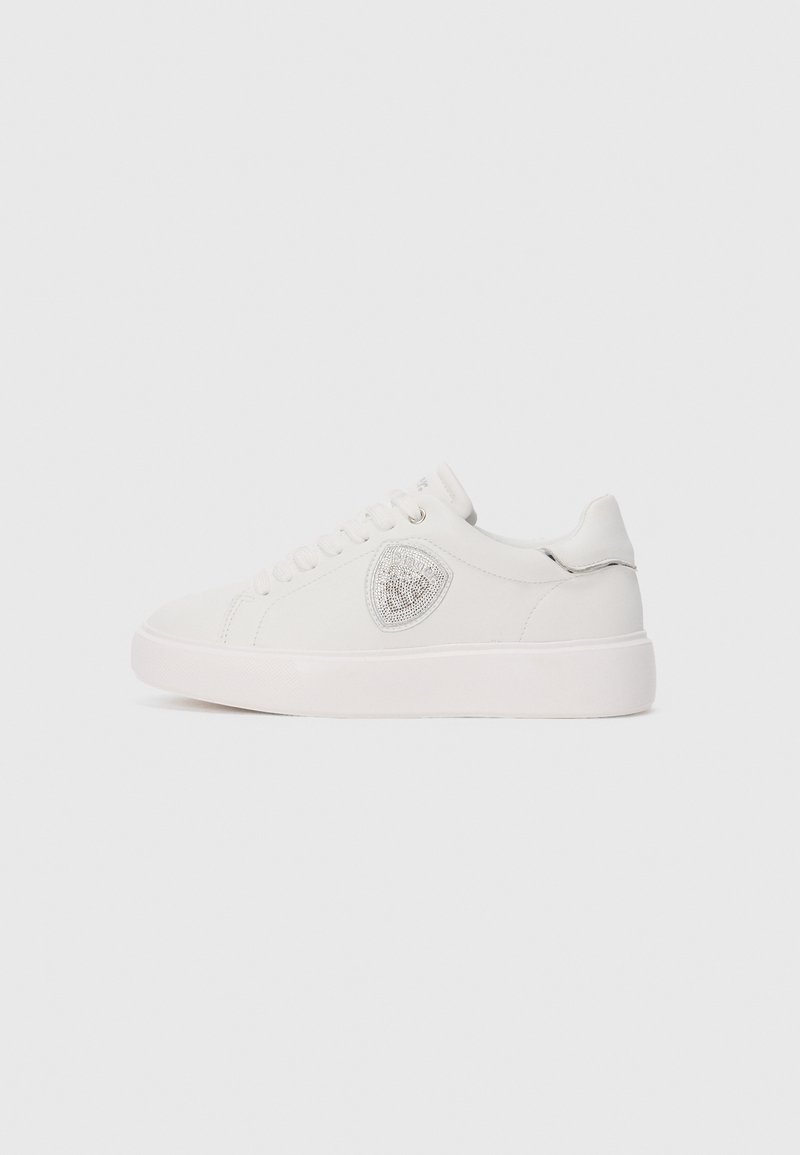 White low-top sneaker with laces, featuring a silver emblem on the side and a subtle silver detail on the heel tab.