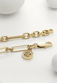 Bracciale in oro con maglie ovali e rettangolari, chiusura a moschettone e ciondolo rotondo con cristalli incastonati.